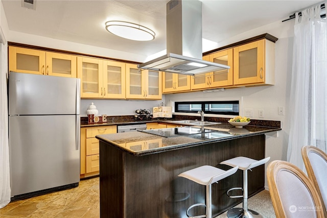 kitchen featuring dishwasher, island exhaust hood, dark stone counters, stainless steel fridge, and kitchen peninsula