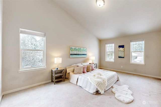 carpeted bedroom with high vaulted ceiling