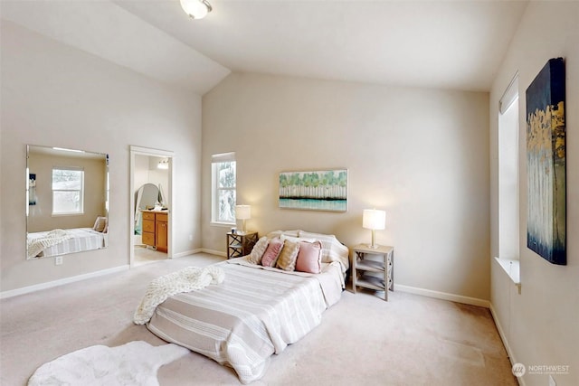 bedroom with multiple windows, connected bathroom, light colored carpet, and lofted ceiling