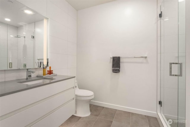 bathroom featuring a shower with shower door, tile walls, vanity, toilet, and tile patterned floors