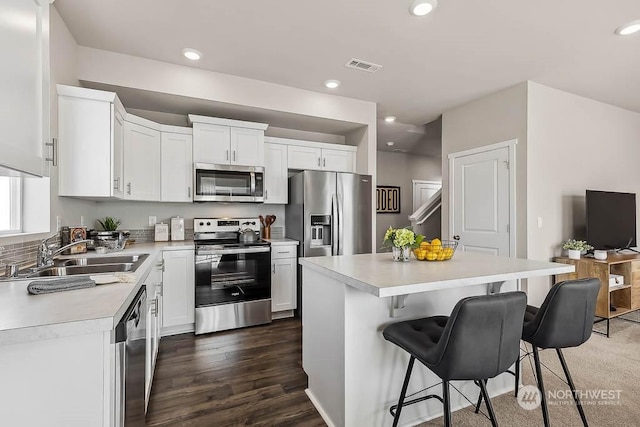 kitchen featuring sink, a center island, white cabinets, and appliances with stainless steel finishes