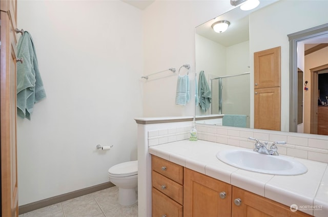 bathroom featuring toilet, decorative backsplash, tile patterned floors, an enclosed shower, and vanity