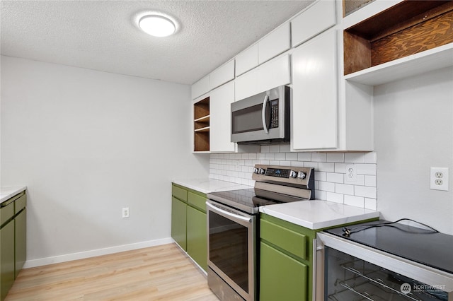 kitchen with a textured ceiling, green cabinets, appliances with stainless steel finishes, and tasteful backsplash