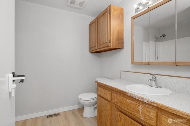 bathroom with a shower, hardwood / wood-style floors, toilet, and vanity