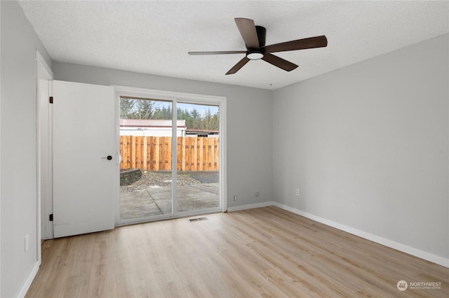 empty room with ceiling fan, a textured ceiling, and light wood-type flooring