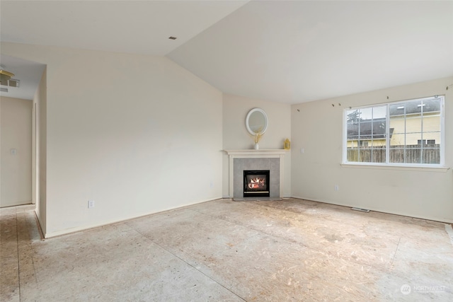 unfurnished living room with a tile fireplace and vaulted ceiling