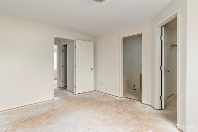 unfurnished bedroom featuring a walk in closet