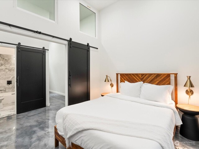 bedroom with ensuite bath and a barn door