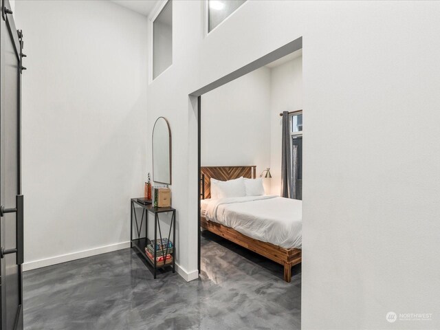 bedroom with a high ceiling and a barn door