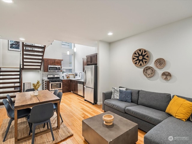 living room featuring sink and light hardwood / wood-style flooring