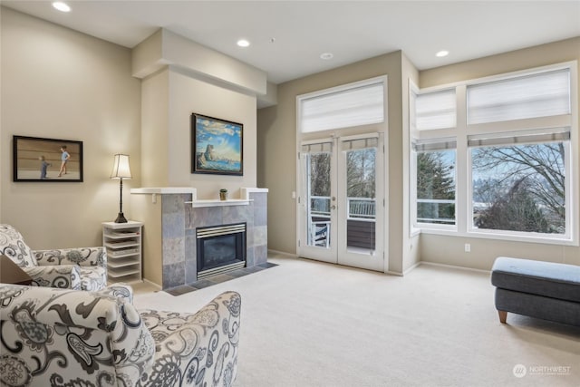 carpeted living room with french doors and a tiled fireplace