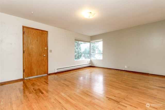 spare room with light wood-type flooring and a baseboard radiator