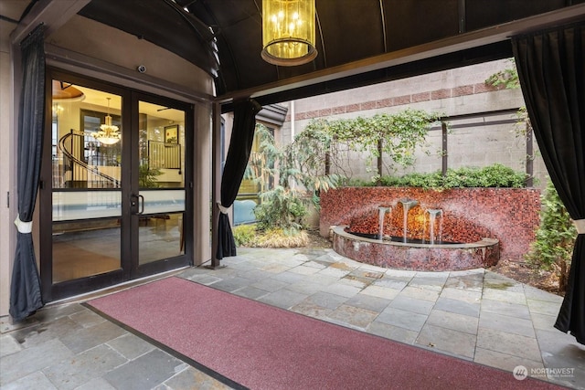 exterior space featuring vaulted ceiling, french doors, and a chandelier