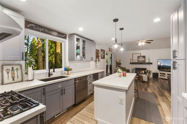 kitchen featuring dishwasher, gray cabinets, a breakfast bar area, ceiling fan, and sink