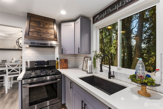 kitchen with gray cabinetry, stainless steel range with gas cooktop, and sink