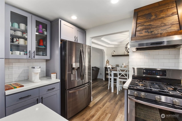 kitchen featuring dark hardwood / wood-style flooring, stainless steel appliances, gray cabinetry, and tasteful backsplash