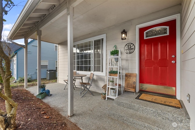 entrance to property featuring a porch and central AC unit