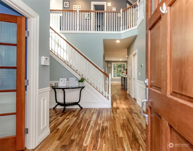 foyer entrance with hardwood / wood-style floors and a high ceiling