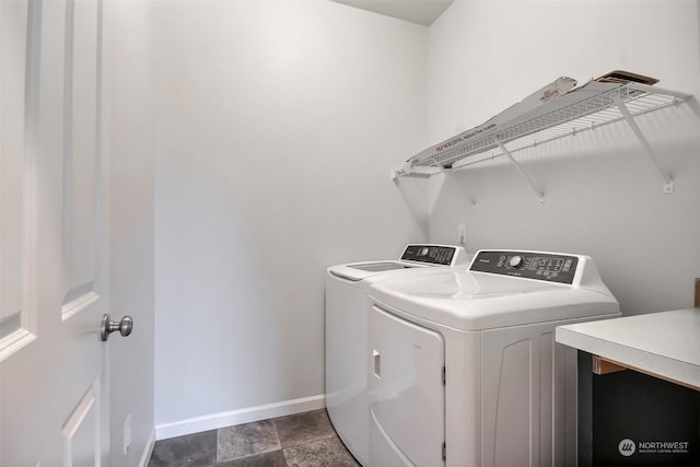 washroom featuring laundry area, baseboards, and separate washer and dryer