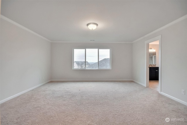 unfurnished room with baseboards, ornamental molding, and light colored carpet