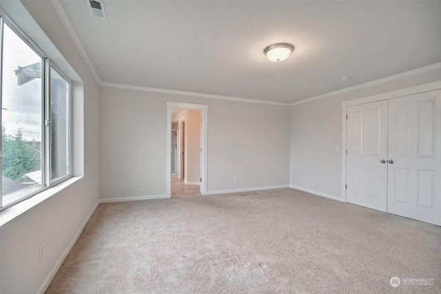 unfurnished bedroom featuring carpet floors, visible vents, crown molding, and baseboards