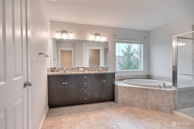 bathroom featuring a stall shower, vanity, a bath, and tile patterned floors