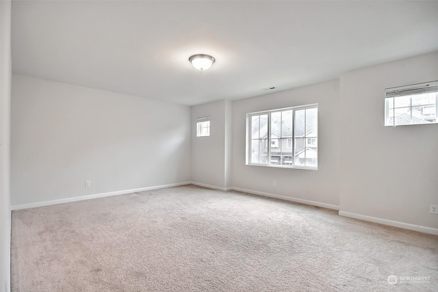 carpeted empty room featuring visible vents and baseboards