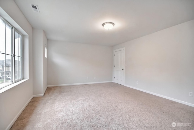 carpeted empty room featuring visible vents and baseboards