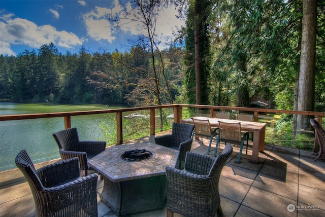 deck featuring an outdoor fire pit and a water view