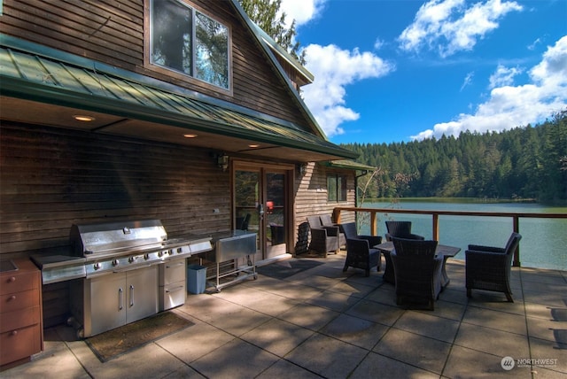 view of patio with a water view and area for grilling