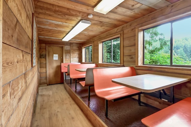 dining area featuring wood-type flooring, wood walls, and wood ceiling