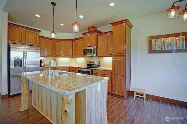 kitchen with sink, decorative light fixtures, a center island with sink, appliances with stainless steel finishes, and light stone countertops