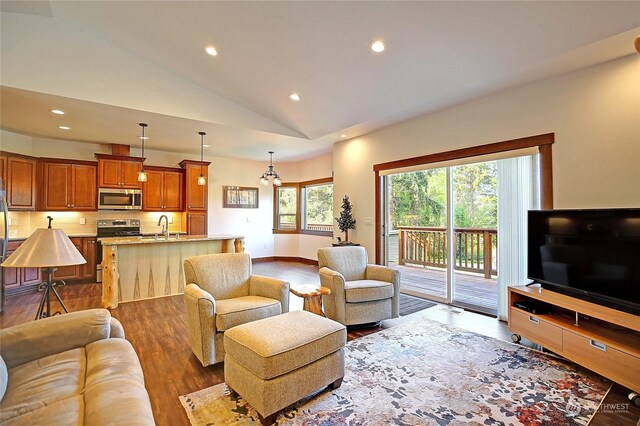 living room with a notable chandelier, hardwood / wood-style flooring, a wealth of natural light, and sink