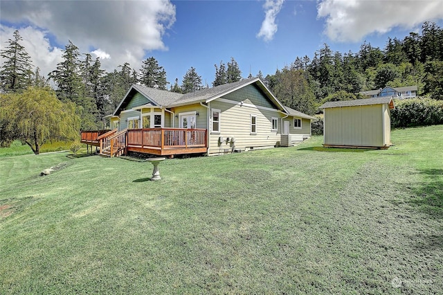 rear view of property with a shed, a wooden deck, and a lawn