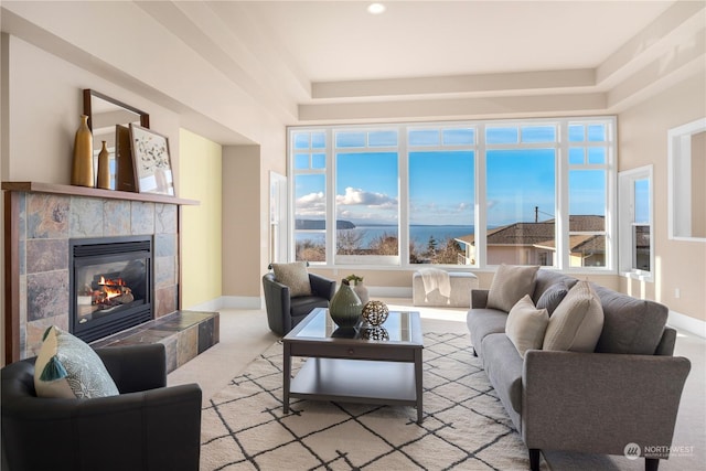 living room with light colored carpet and a tiled fireplace