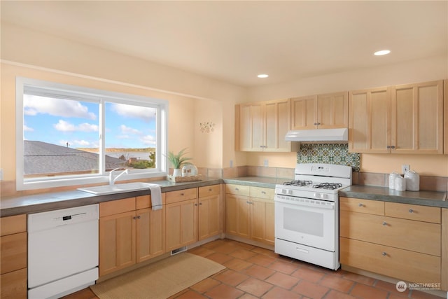 kitchen featuring white appliances, light brown cabinetry, sink, backsplash, and light tile patterned flooring