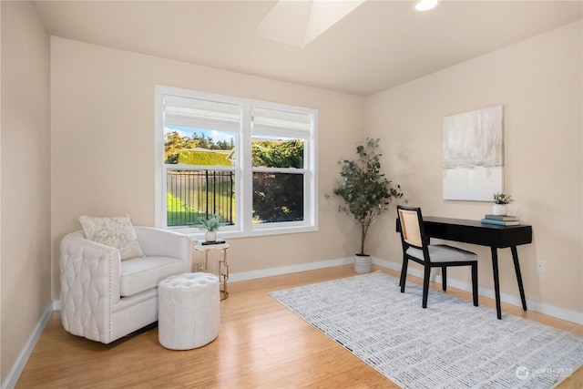 office area featuring a skylight and light hardwood / wood-style floors