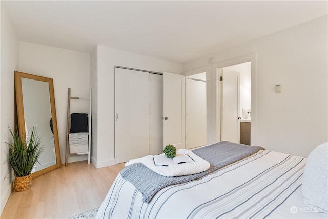 bedroom with light hardwood / wood-style floors and a closet