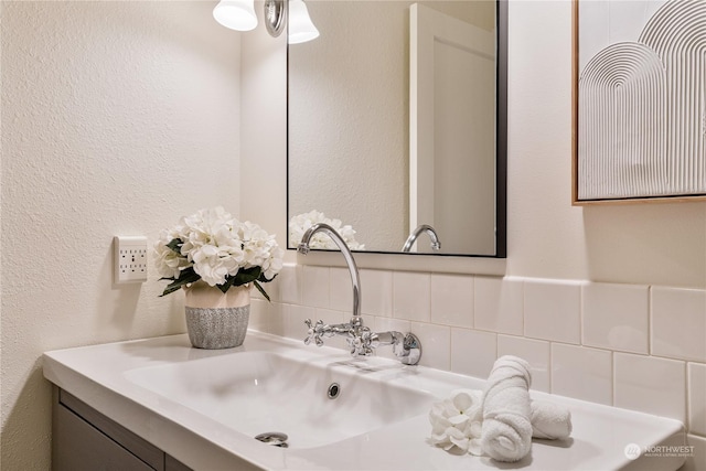 bathroom featuring vanity and backsplash