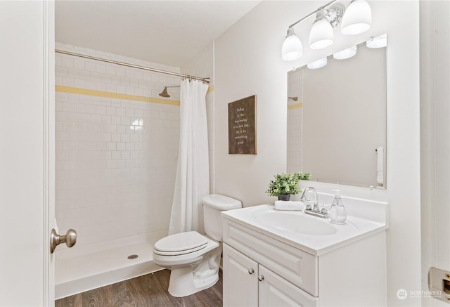 bathroom featuring toilet, hardwood / wood-style flooring, a shower with shower curtain, and vanity