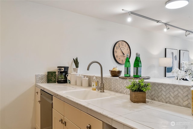 kitchen with stainless steel dishwasher, backsplash, and sink