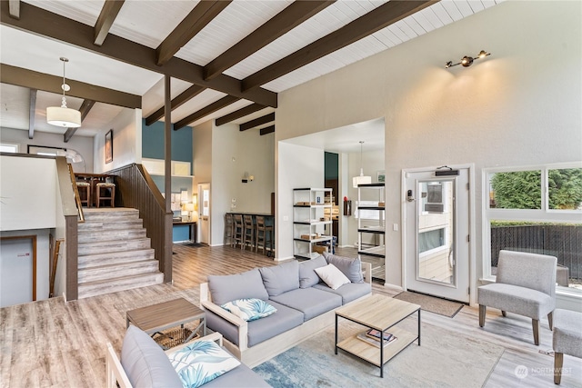 living room featuring light hardwood / wood-style flooring, high vaulted ceiling, and beamed ceiling