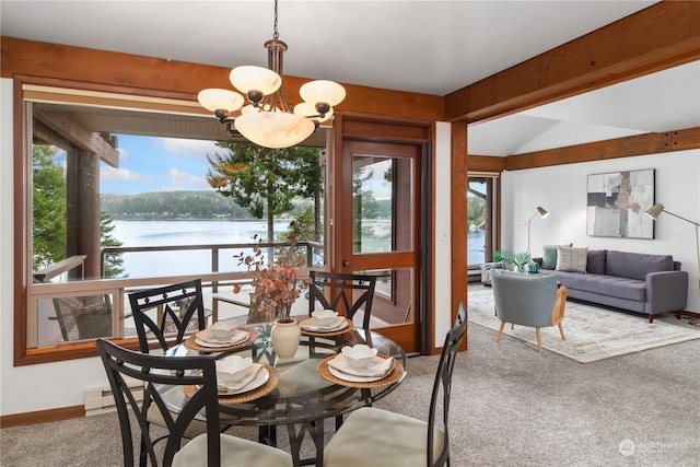 dining space featuring a water view, carpet flooring, and a chandelier