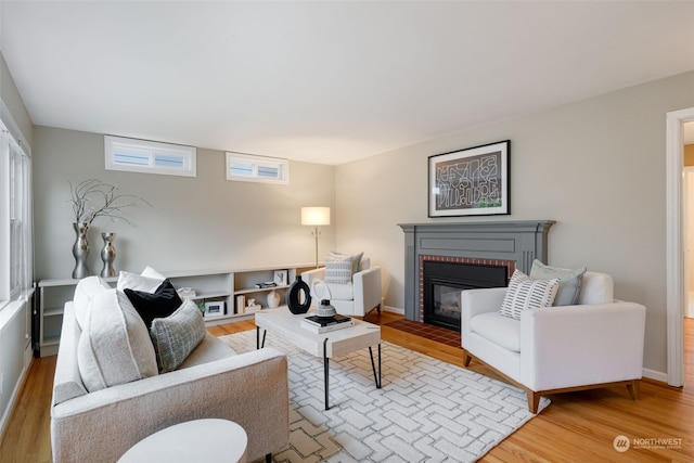 living room featuring a brick fireplace and hardwood / wood-style flooring