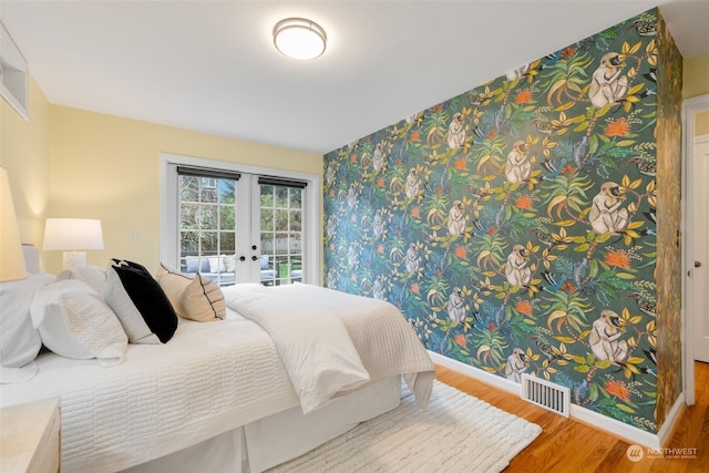 bedroom with french doors, access to exterior, and hardwood / wood-style floors