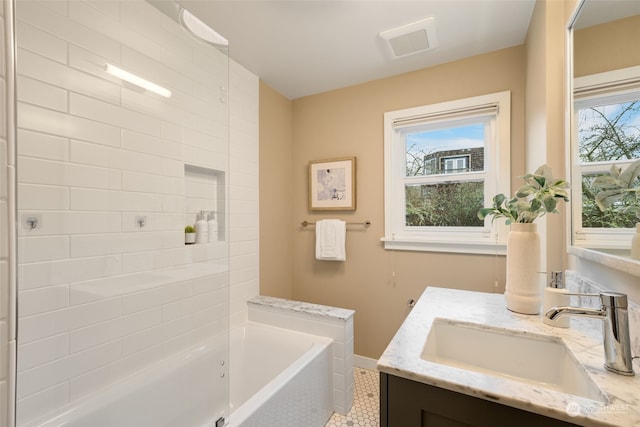 bathroom with tile patterned floors, vanity, and a washtub