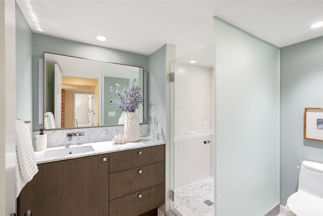 bathroom with a shower with shower door, backsplash, vanity, and toilet