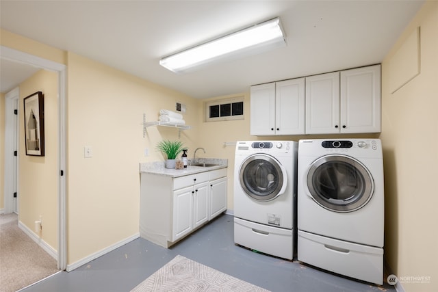 clothes washing area featuring sink, cabinets, and washer and clothes dryer