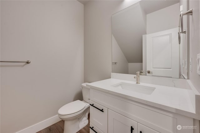 bathroom featuring toilet, hardwood / wood-style flooring, and vanity