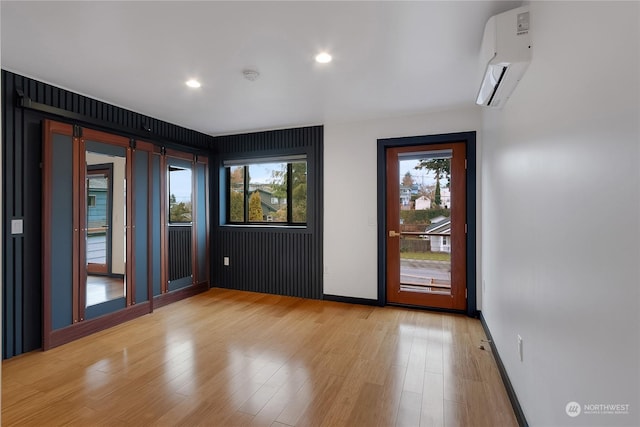 spare room featuring light hardwood / wood-style flooring and a wall mounted air conditioner